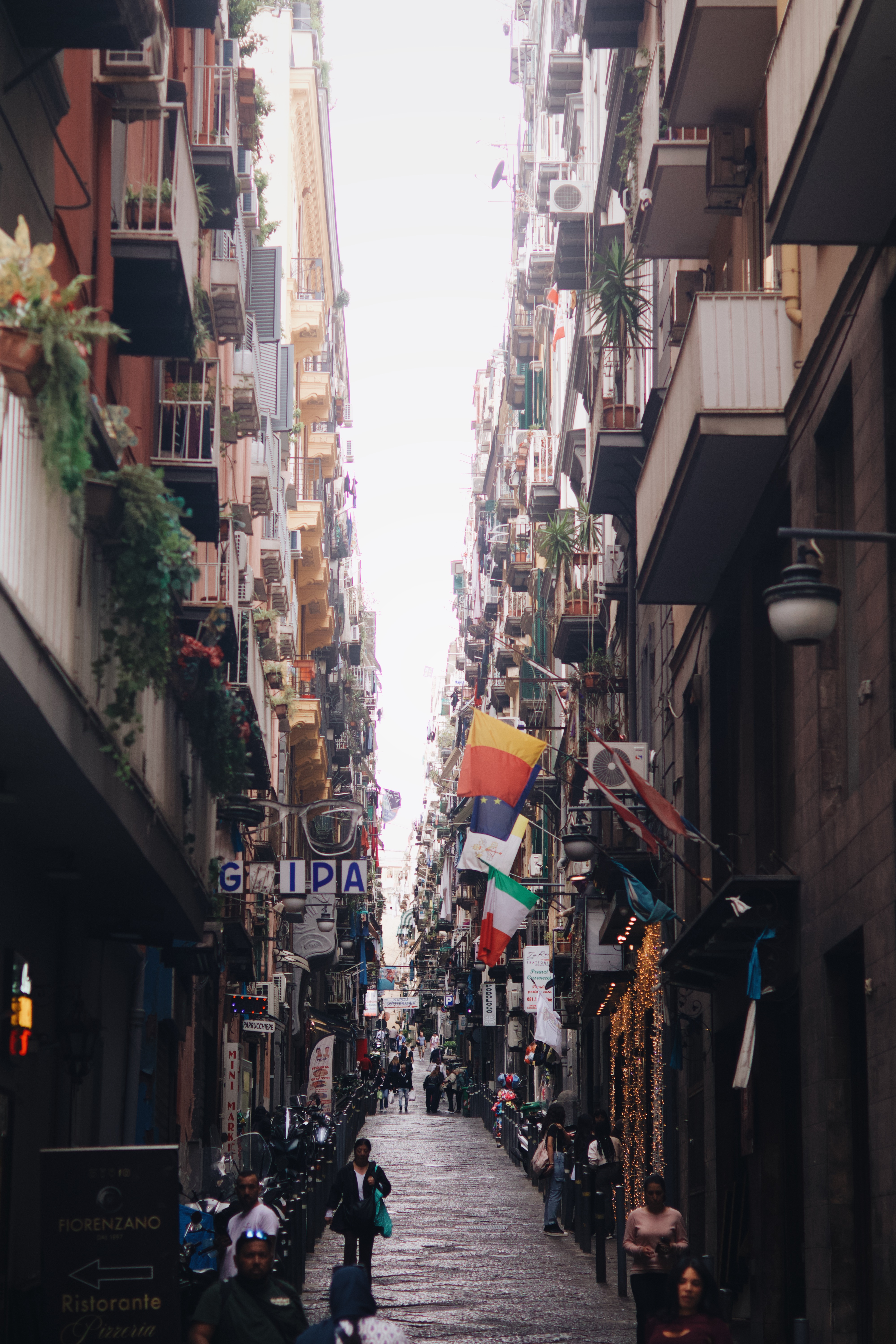 Rua estreita e movimentada no centro de Nápoles