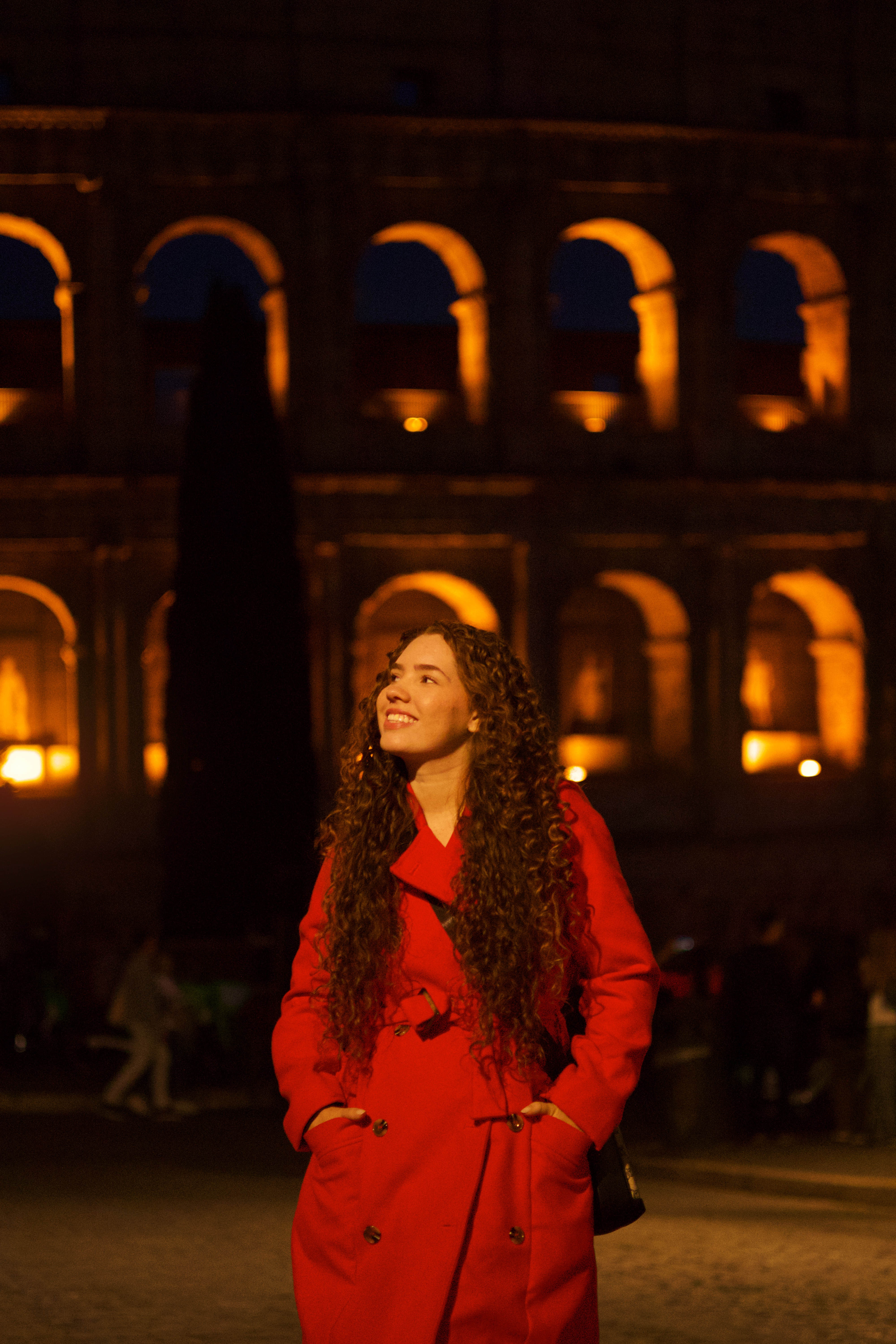 Retrato noturno com vestido vermelho diante do Coliseu