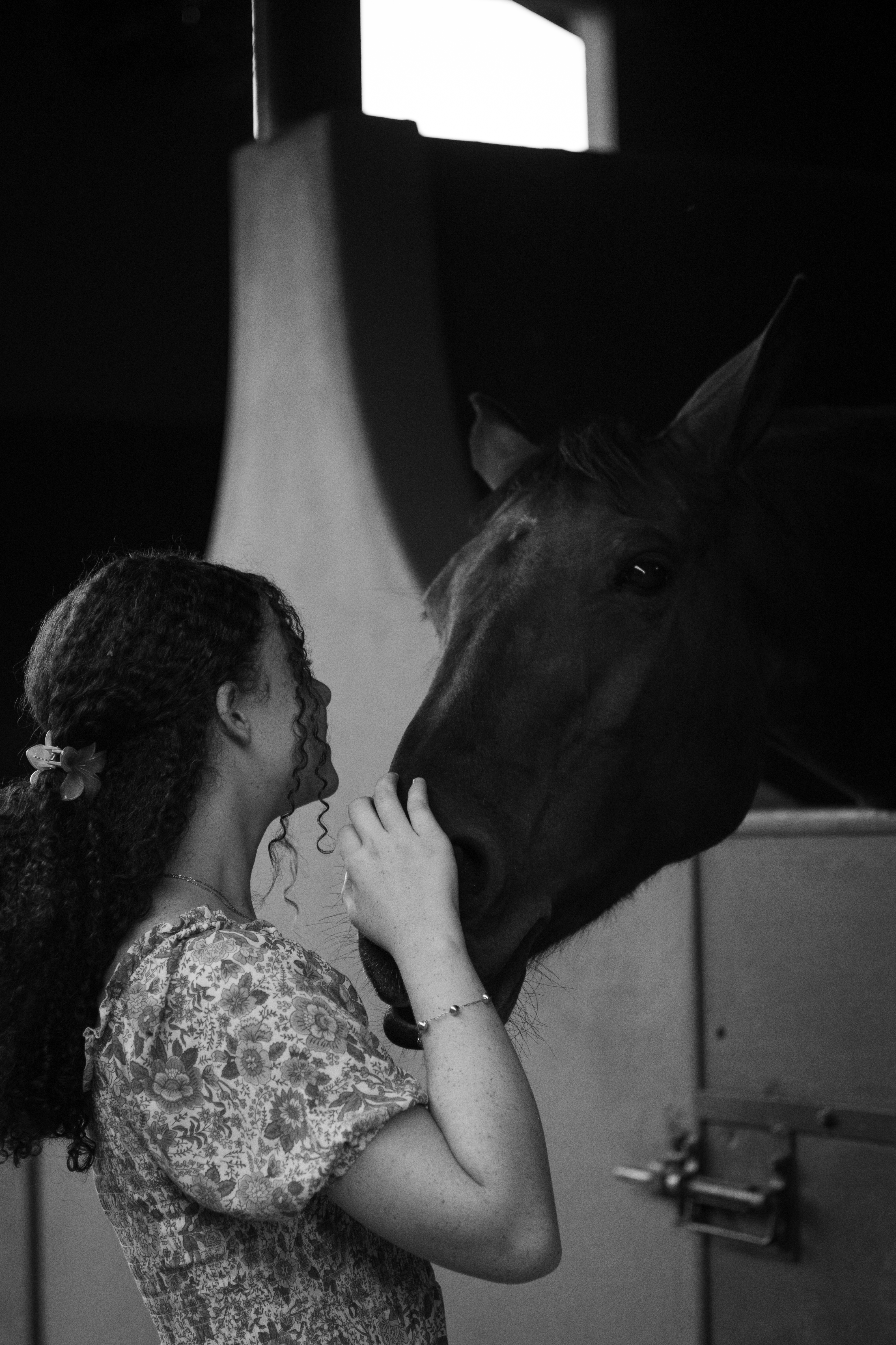 Allana sentada junto a uma janela em fotografia preto e branco